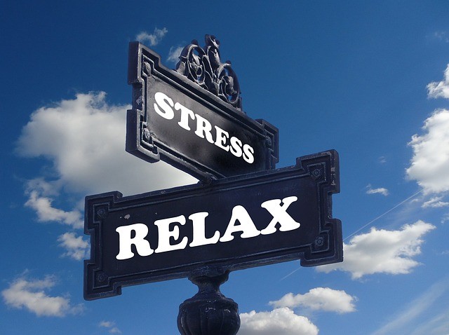 Panneau à double sens qui affiche "relax" et "stress" sur fond de ciel bleu avec quelques nuage