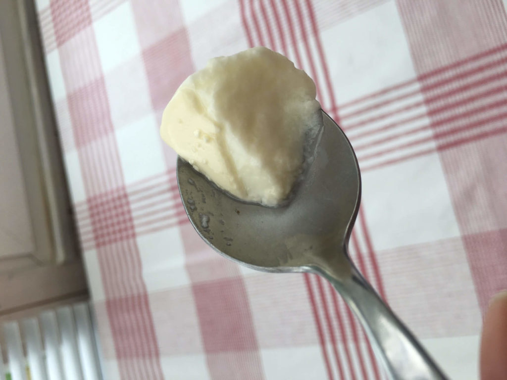 Cuillère avec du yaourt ayant une petite couche de crème