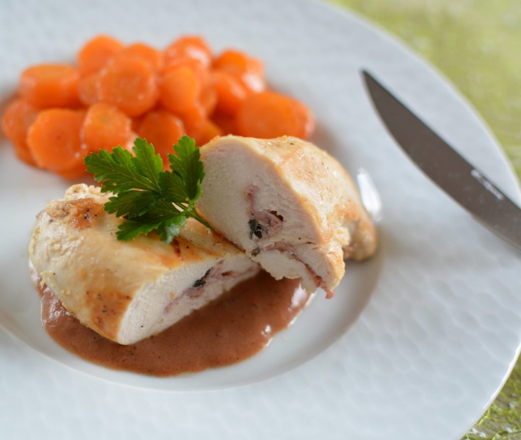 escalope de poulet coupée en deux, une feuille de persil posée dessus et avec des carottes coupées en rondelles