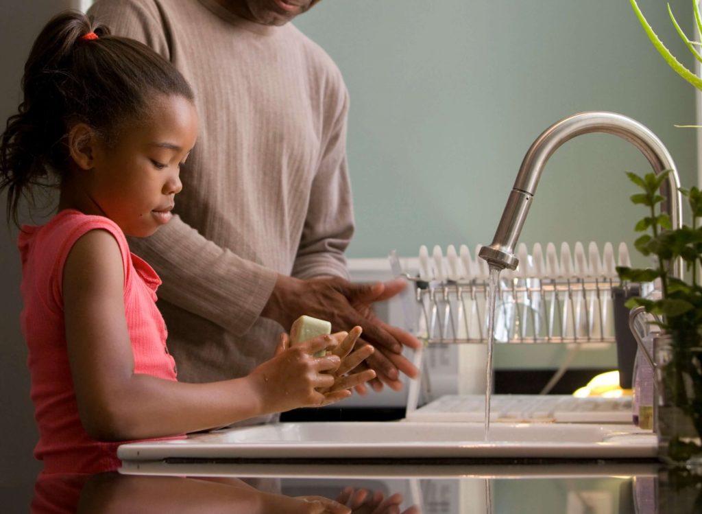 Petites fille en train de se laver les mains dans une cuisine